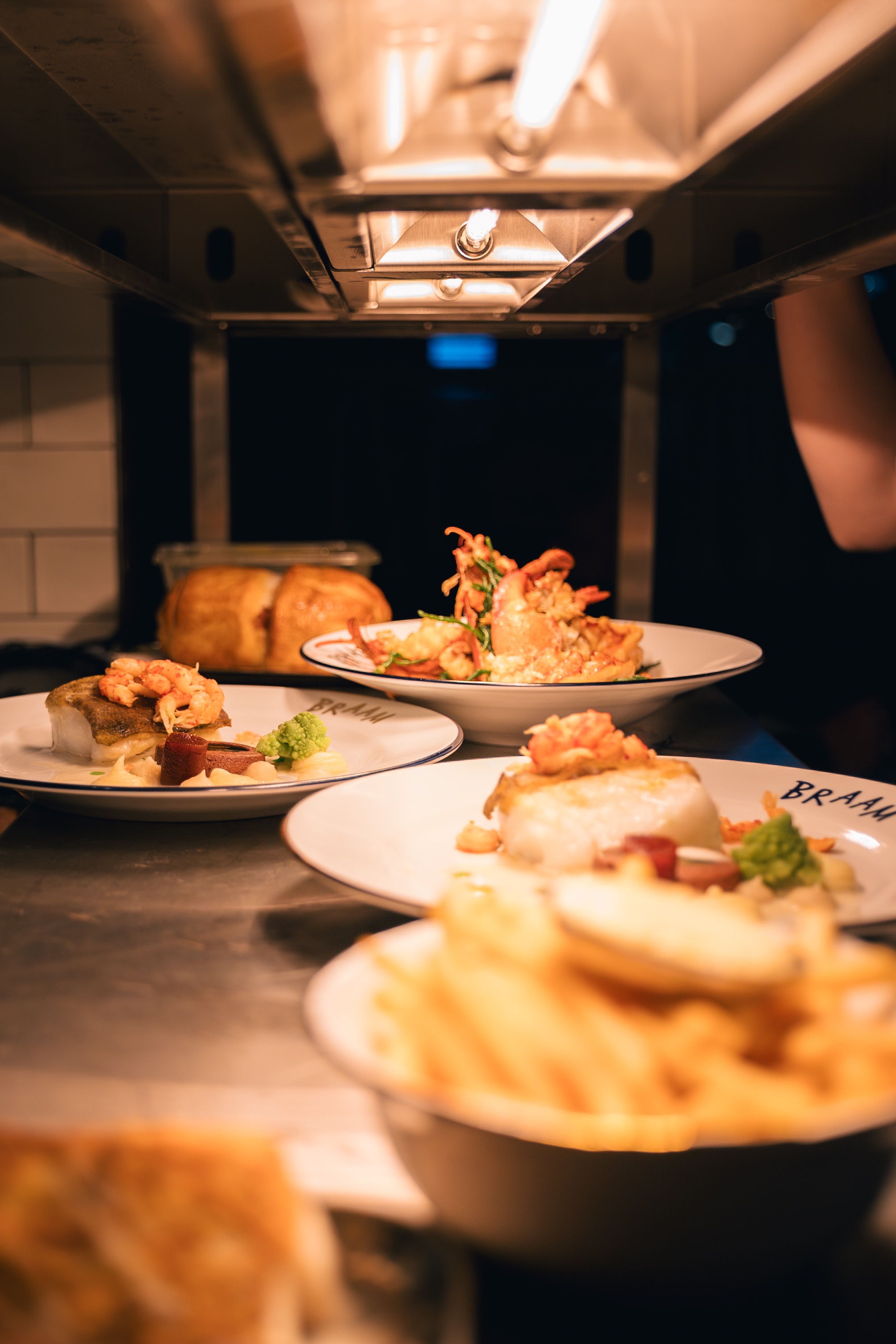 Gerechten op de pass in de keuken van Maison du Braam