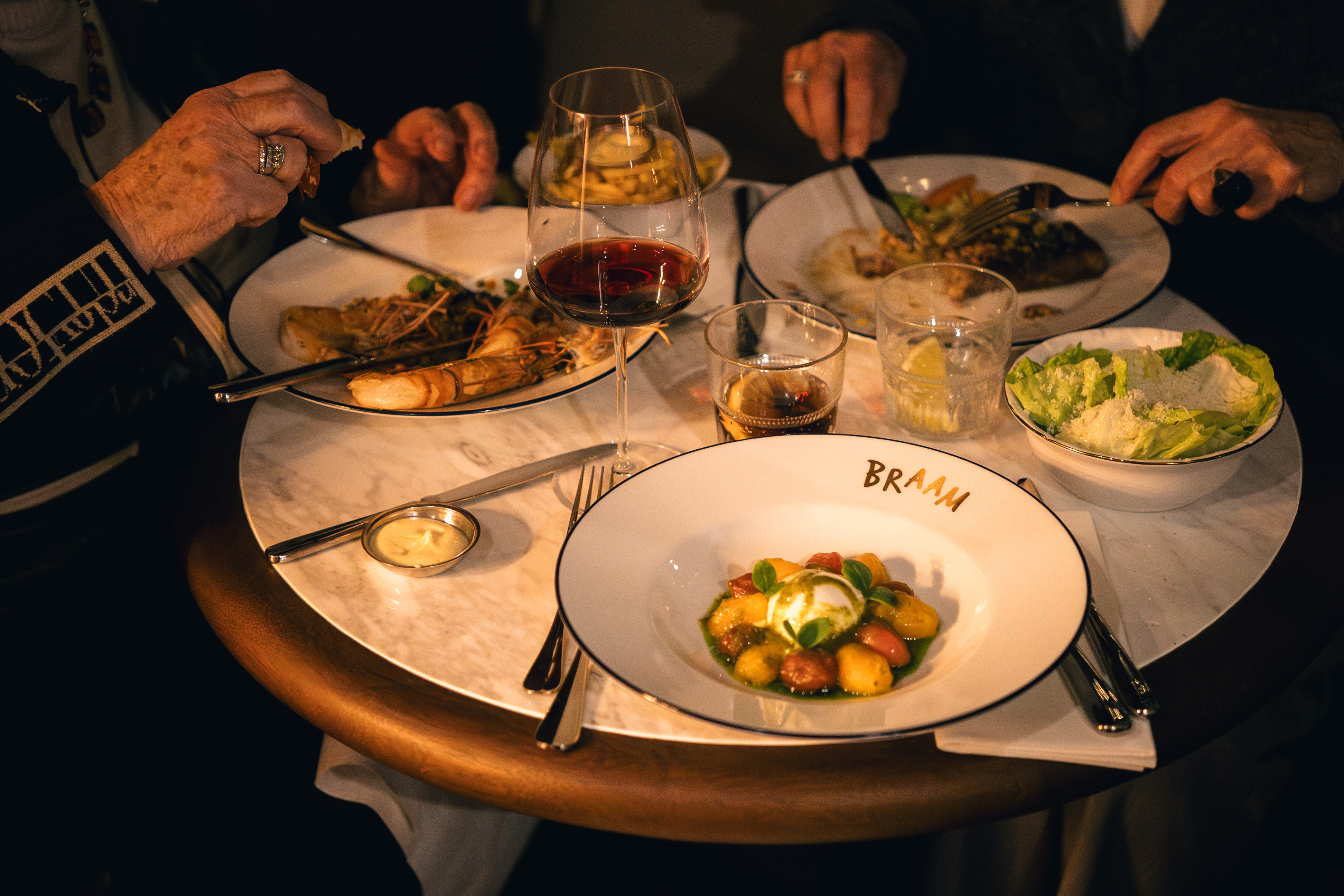Tafel met bistrogerechten en wijn bij Maison du Braam